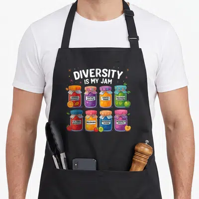 Tablier de cuisine noir avec illustration de jars colorés portant des messages sur la diversité et l'inclusion.
