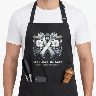 Tablier de cuisine noir avec ruban gris, illustration de cerveau floral et texte Go Gray In May Brain Tumor Awareness.