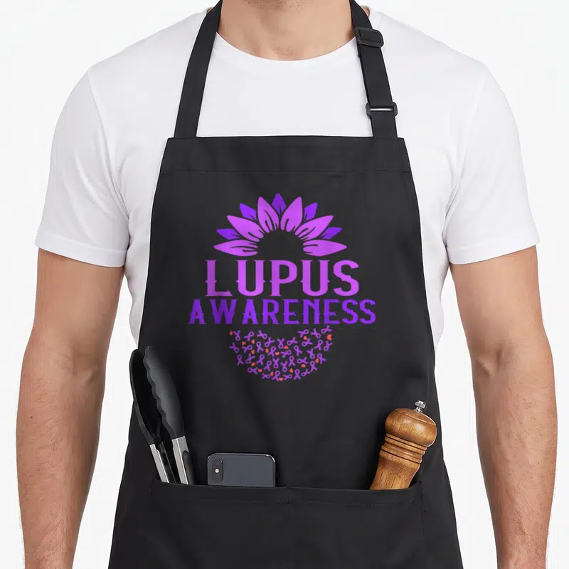 Tablier de cuisine noir avec une tournesol violette et le texte Lupus Awareness au centre.