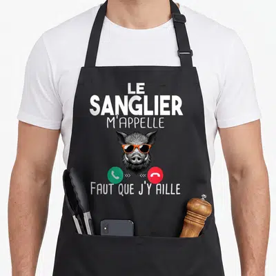 Tablier de cuisine noir avec illustration d'un sanglier portant des lunettes orange et des icônes d'appel téléphonique vert et rouge.