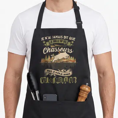 Tablier de cuisine noir avec illustration d'un sanglier et texte humoristique sur la chasse en lettres vintage beige et vert olive.
