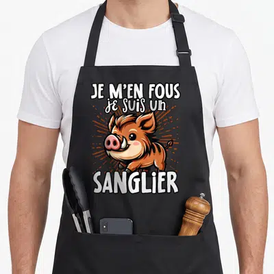 Tablier de cuisine noir avec une illustration colorée d'un sanglier marron et du texte blanc Je m'en fous je suis un sanglier.