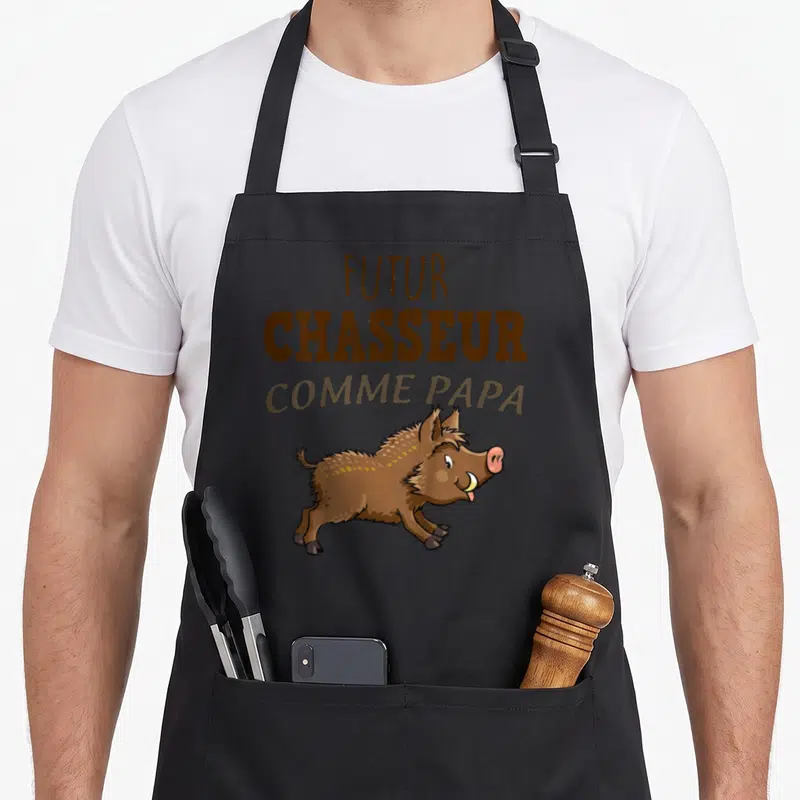 Tablier de cuisine noir avec illustration d'un petit sanglier et texte futur chasseur comme papa