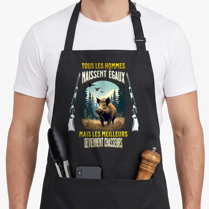 Tablier de cuisine noir avec illustration d'un sanglier, de fusils et le texte tous les hommes naissent égaux mais les meilleurs deviennent chasseurs
