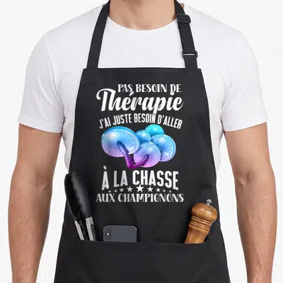 Tablier de cuisine noir avec l'inscription Pas besoin de thérapie et des champignons bleus stylisés au centre du vêtement.