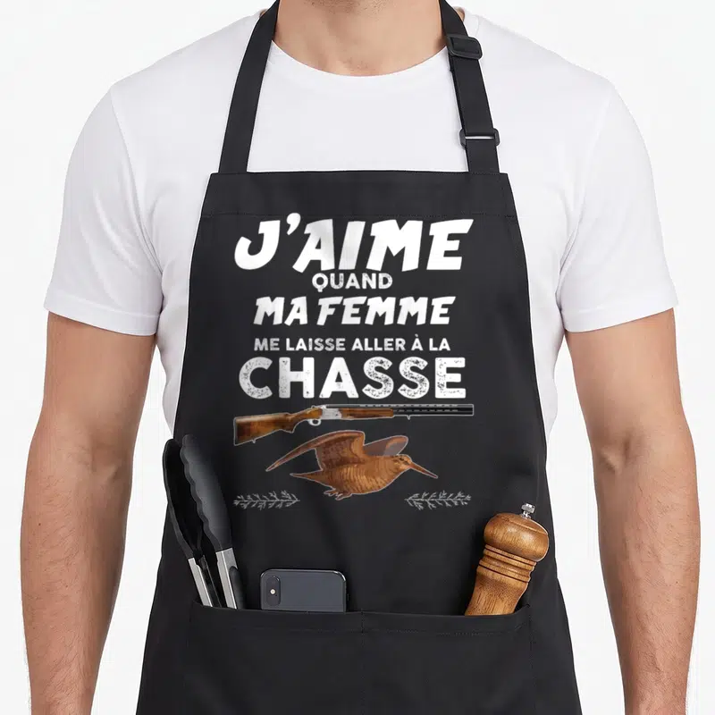 Tablier de cuisine noir avec inscription J'aime quand ma femme me laisse aller à la chasse et dessin d'une bécasse au-dessus d'un fusil.
