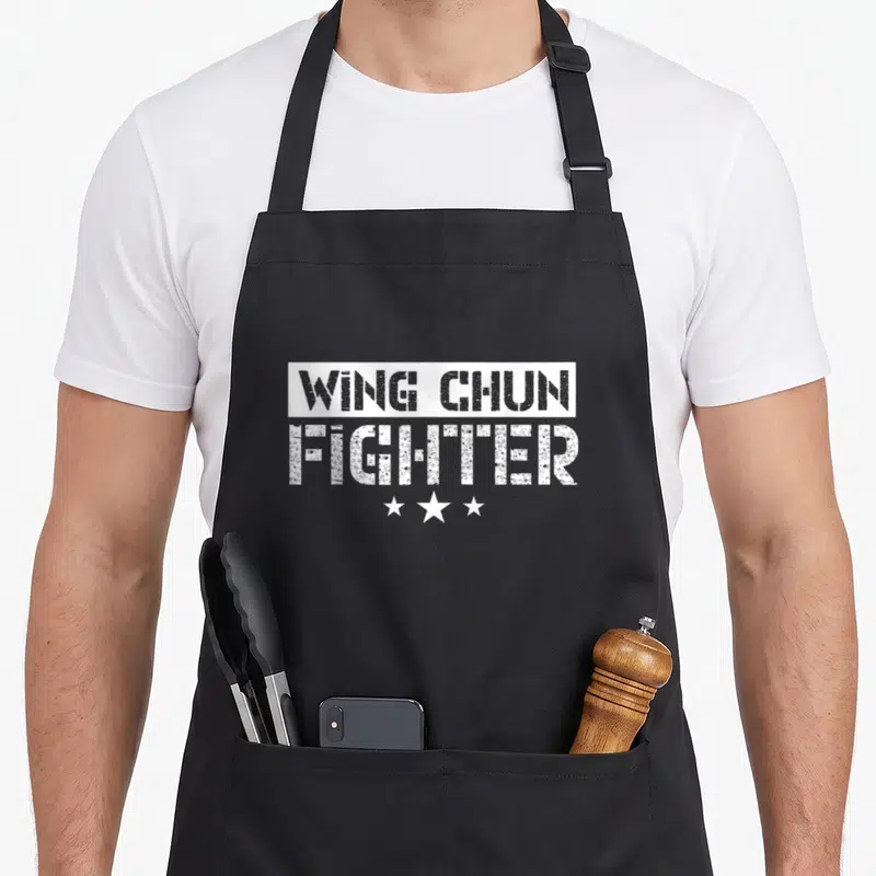 Tablier de cuisine noir avec inscription Wing Chun Fighter et trois étoiles blanches stylisées.