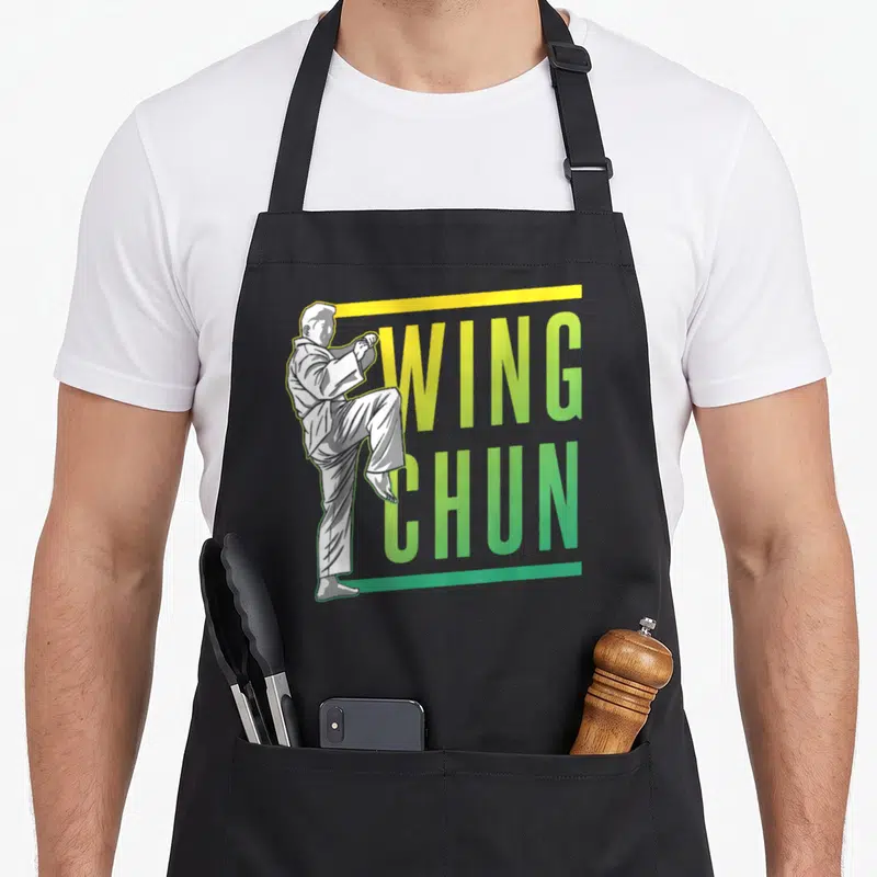 Tablier de cuisine noir avec illustration d'un pratiquant de Wing Chun et texte WING CHUN en dégradé vert et jaune.