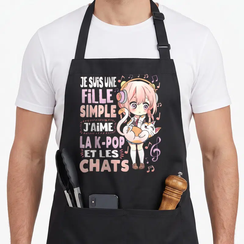 Tablier de cuisine noir avec une illustration anime rose et blanche d'une fille tenant un chat entourée de notes de musique et du texte Je suis une fille simple J'aime la K-Pop et les chats.