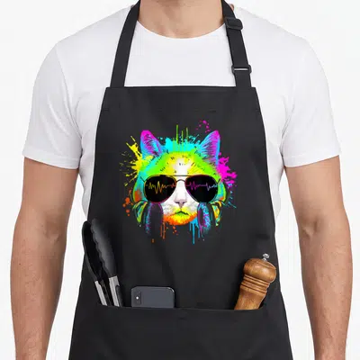Tablier de cuisine noir avec illustration d'un chaton aux couleurs vives portant des lunettes de soleil à ondes sonores.
