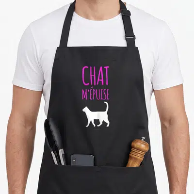 Tablier de cuisine noir avec inscription rose vif Chat m'épuise et silhouette de félin blanc.