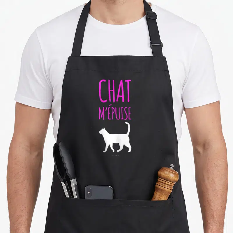 Tablier de cuisine noir avec inscription rose vif Chat m'épuise et silhouette de félin blanc.
