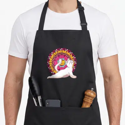 Tablier de cuisine noir avec illustration d'un chat blanc en post devant un mandala de têtes félines colorées.