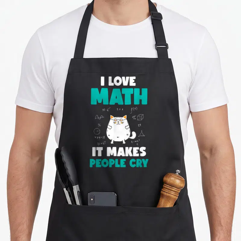 Tablier de cuisine noir avec un chat blanc aux lunettes entouré de symboles mathématiques et du texte « I love math it makes people cry ».