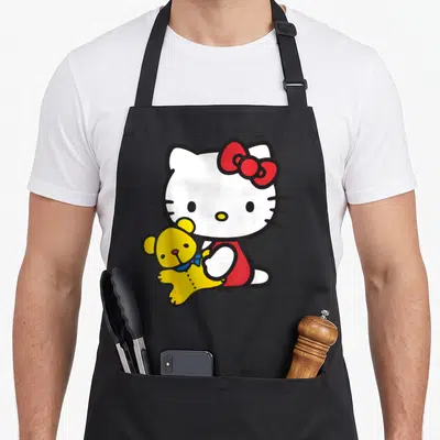 Tablier de cuisine noir avec Hello Kitty blanche tenant un ours jaune à nœud bleu.
