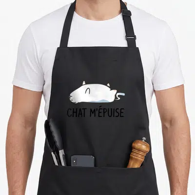 Tablier de cuisine noir avec un chat blanc allongé et le texte chat m'épuise imprimé en dessous.