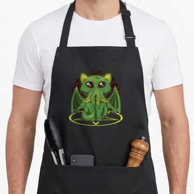 Tablier de cuisine noir avec un chat vert Cthulhu Satanic Kawaii aux ailes de dragon et yeux roses sur pentagramme.