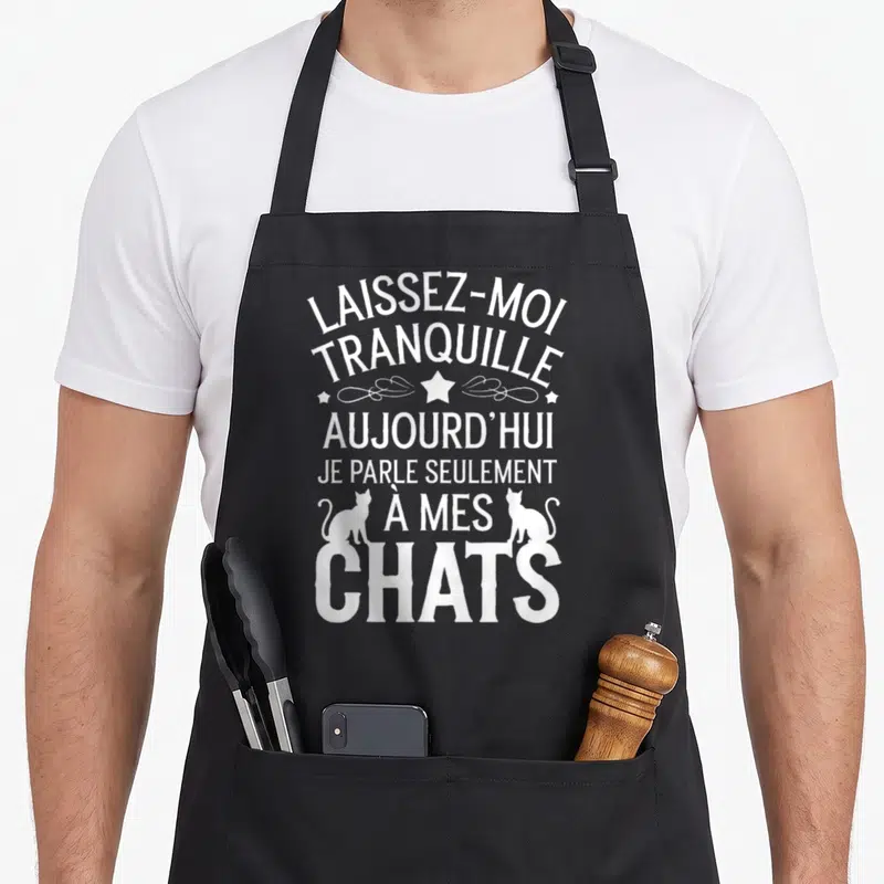 Tablier de cuisine noir avec le texte blanc Laissez-moi tranquille aujourd'hui je parle seulement à mes chats flanqué de deux silhouettes de chats.