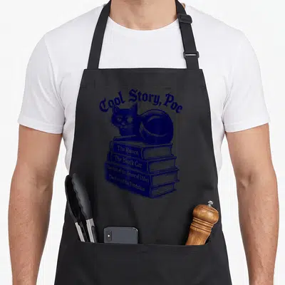 Tablier de cuisine noir avec un chat noir assis sur une pile de livres bleus et le texte Cool Story Poe en haut.