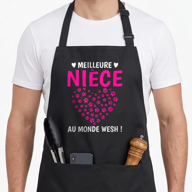 Tablier de cuisine noir avec inscription Meilleure nièce au monde wish et cœur rose fait de pattes d'animaux et de petits cœurs.