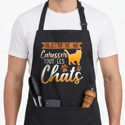 Tablier de cuisine noir avec un chat orange et l'inscription objectif de vie caresser tous les chats.