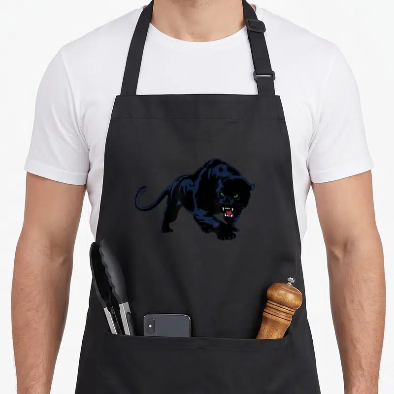Tablier de cuisine noir avec illustration d'une panthère noire aux yeux verts et dents découvertes.