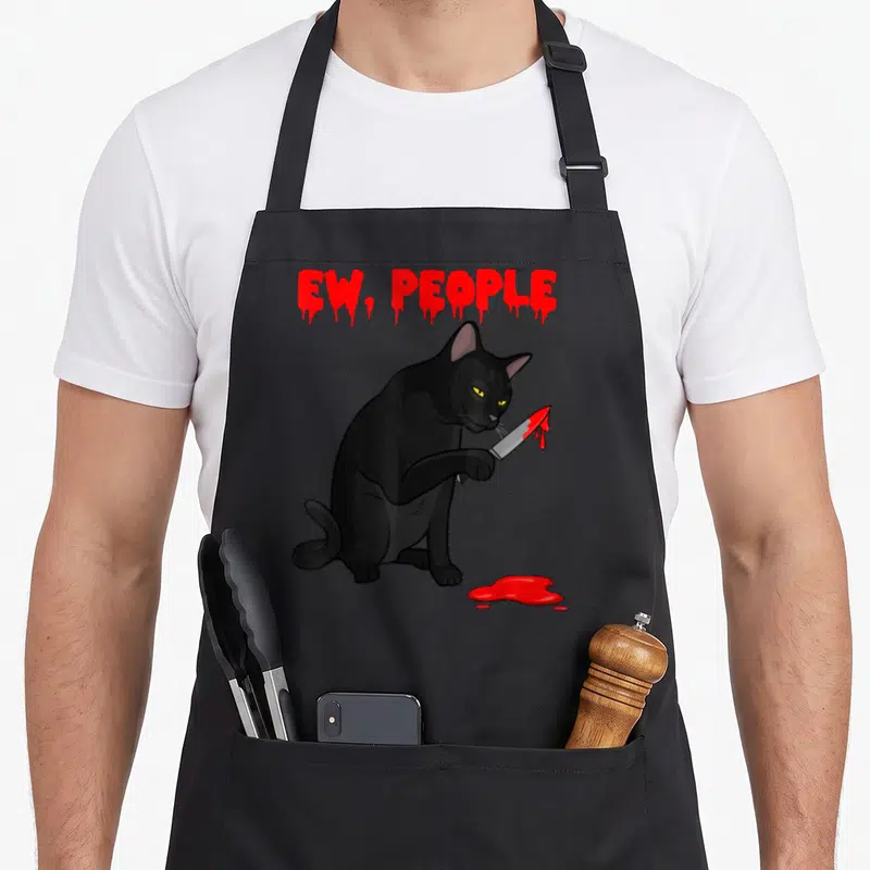Tablier de cuisine noir avec illustration d'un chat noir tenant un couteau ensanglanté sous le texte Ew Gens en lettres rouges.