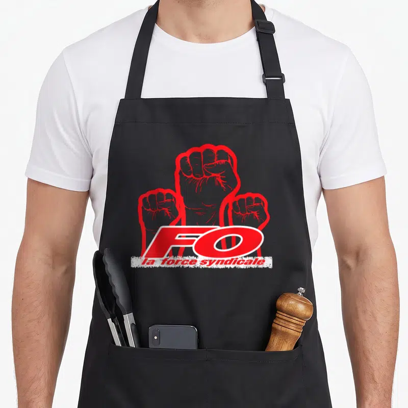 Tablier de cuisine noir avec trois poings fermes rouges et le sigle FO la force syndicale imprimé au centre.