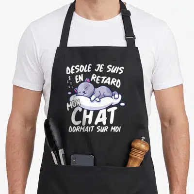 Tablier de cuisine noir avec illustration d'un chat gris dormant et le texte Desole je suis en retard mon chat dormait sur moi