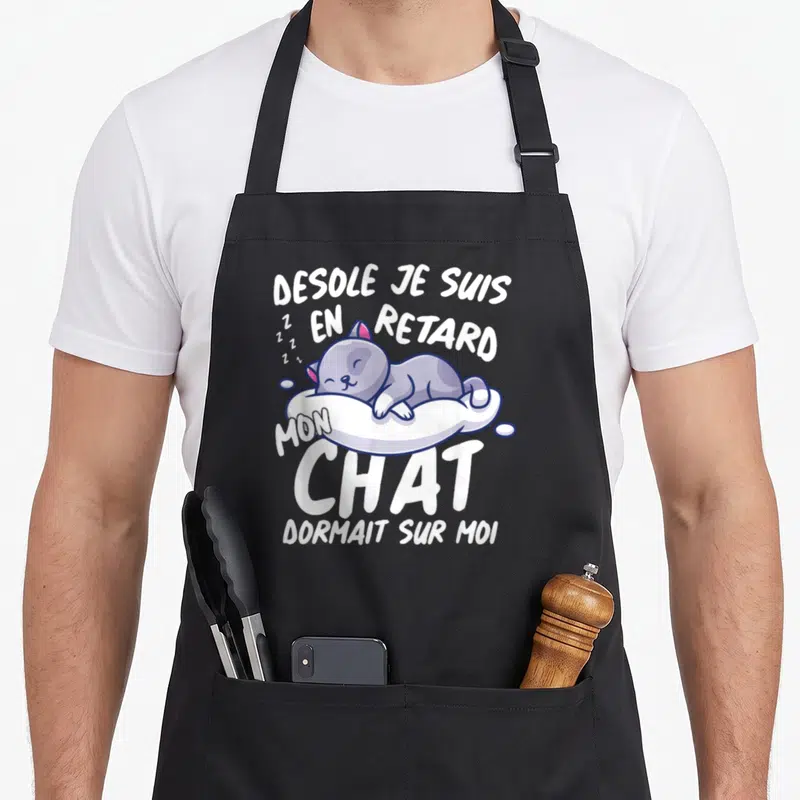 Tablier de cuisine noir avec illustration d'un chat gris dormant et le texte Desole je suis en retard mon chat dormait sur moi
