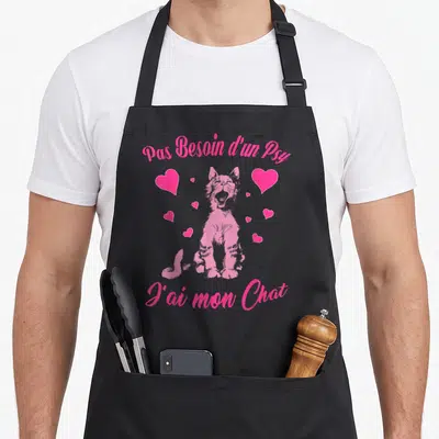 Tablier de cuisine noir avec un chaton rose criant et le texte « Pas Besoin d'un Psy J'ai mon Chat » entouré de cœurs.