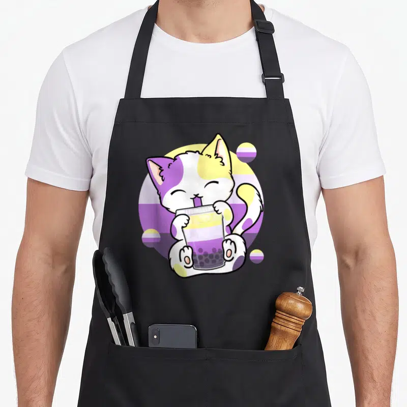 Tablier de cuisine noir avec un chaton blanc et violet buvant du thé à bulles sur fond circulaire coloré.