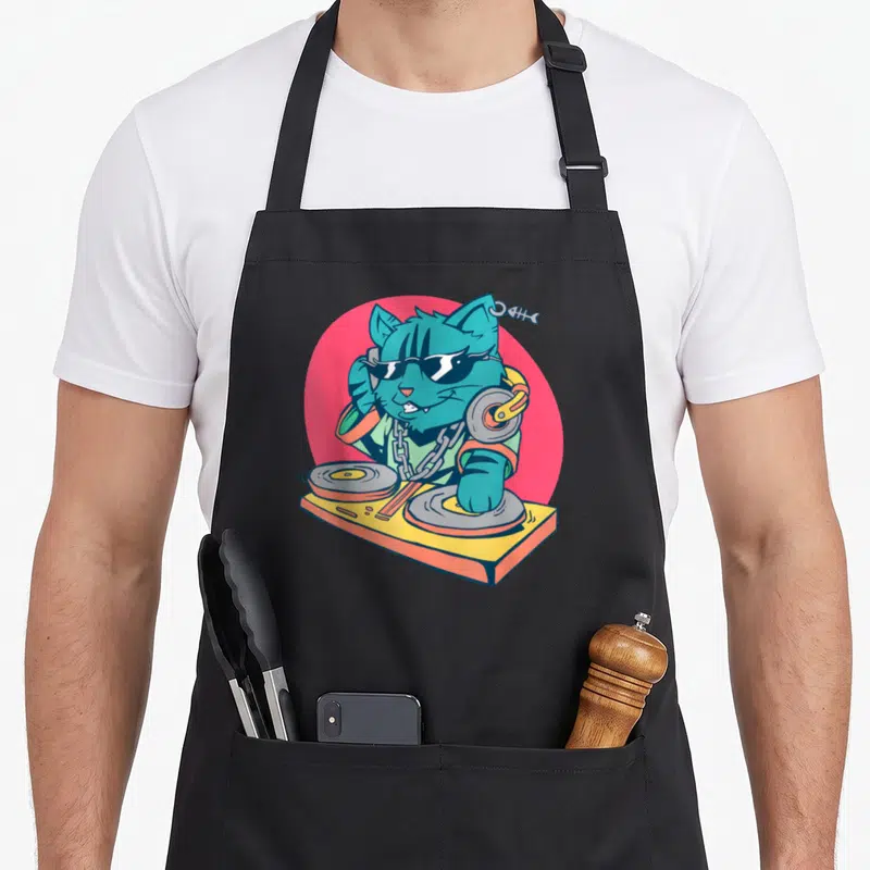 Tablier de cuisine noir avec un chat turquoise en DJ portant des lunettes de soleil sur fond rose.