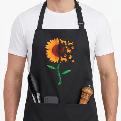 Tablier de cuisine noir avec grand tournesol orange et silhouettes de chats et chiens en adhésion.