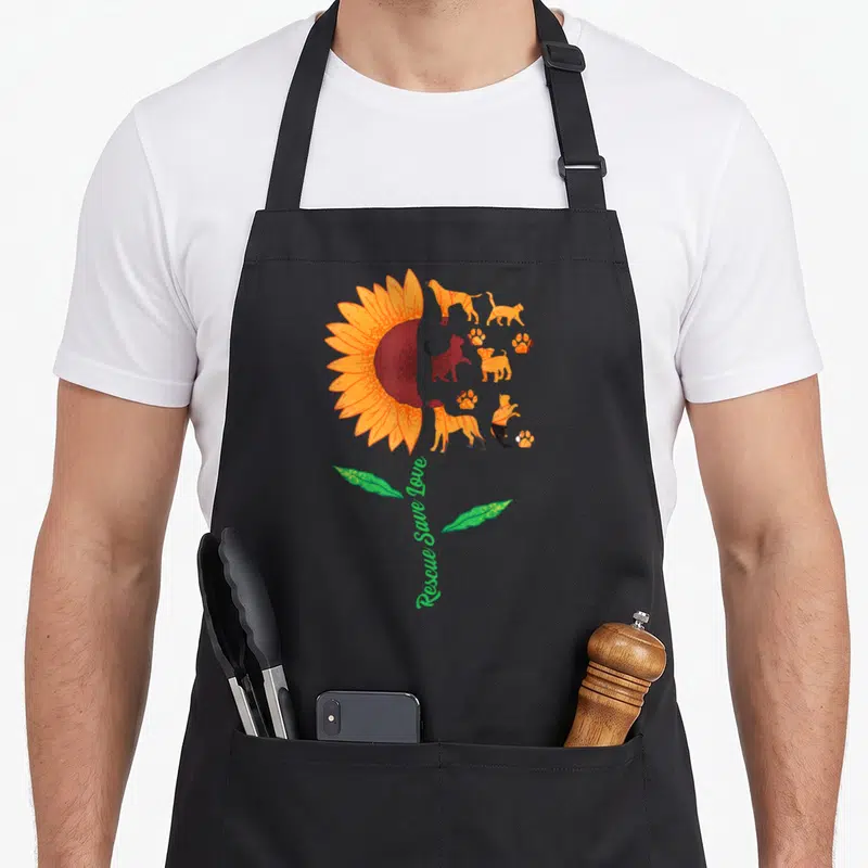 Tablier de cuisine noir avec grand tournesol orange et silhouettes de chats et chiens en adhésion.
