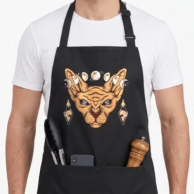 Tablier de cuisine noir avec tête de chat Sphynx orange, flacons magiques et phases de lune en illustration gothique.