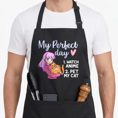 Tablier de cuisine noir avec une illustration anime rose et un chat orange tenant dans les bras.
