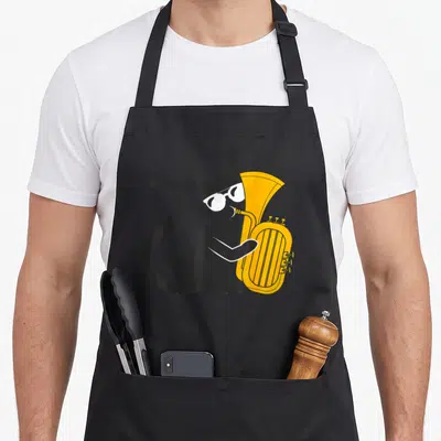 Tablier de cuisine noir avec un chat noir jouant d'un instrument de musique jaune doré et portant des lunettes blanches.