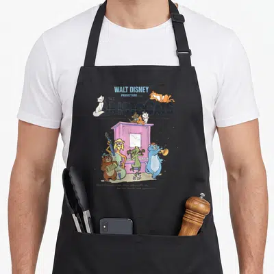 Tablier de cuisine noir avec illustration colorée du groupe de chats musiciens des Aristocats sur fond gris uni.
