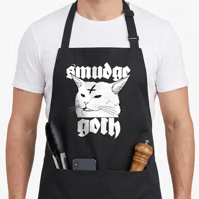 Tablier de cuisine noir avec illustration tête de chat Smudge Goth en noir et blanc et texte gothique.