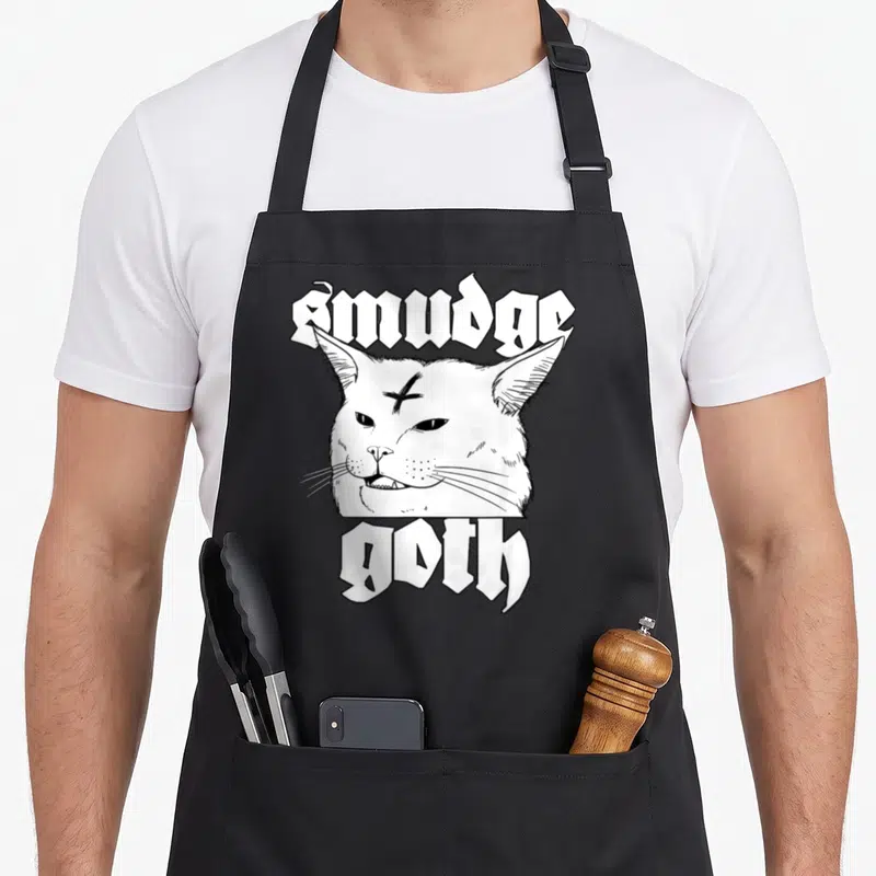 Tablier de cuisine noir avec illustration tête de chat Smudge Goth en noir et blanc et texte gothique.