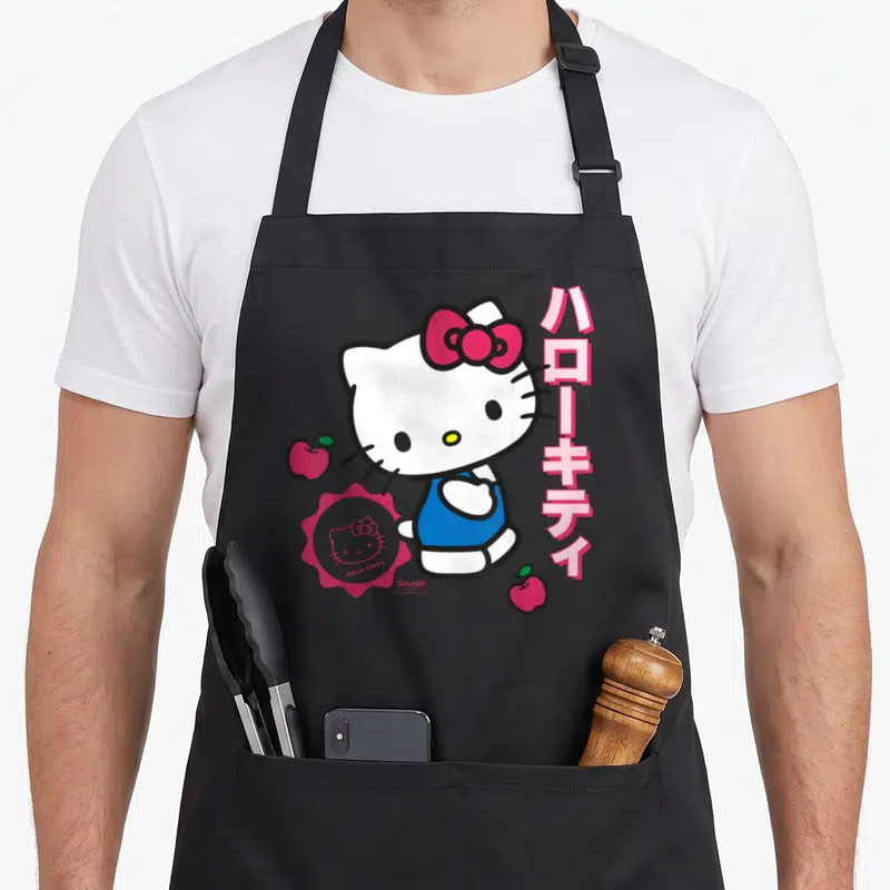 Tablier de cuisine noir avec Hello Kitty au nœud rose, harakitty en vertical et deux pommes rouges.