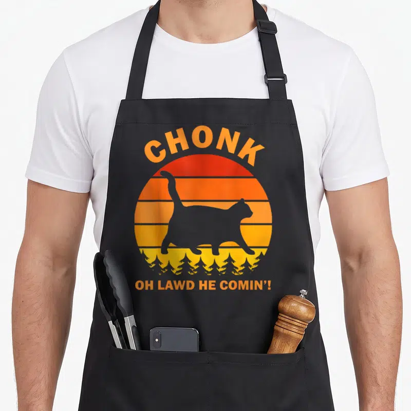 Tablier de cuisine noir avec silhouette de chat potelé sur fond de soleil orange et texte Chonk Oh Lawd He Comin