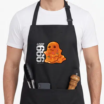 Tablier de cuisine noir avec une illustration orange de SCP-999 et des biscuits colorés.