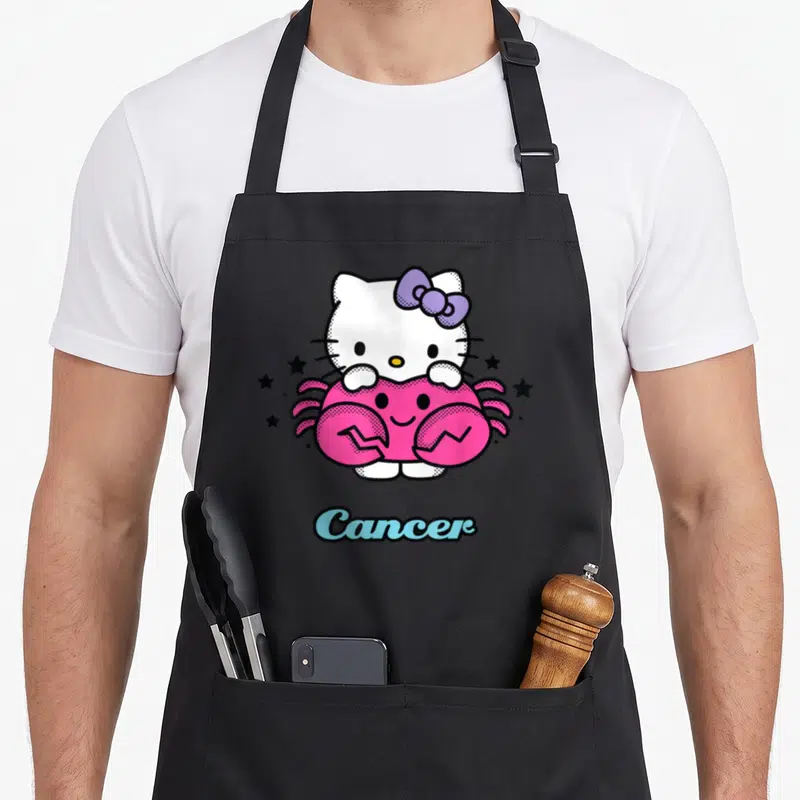 Tablier de cuisine noir avec Hello Kitty tenant un crabe rose sous le mot Cancer.