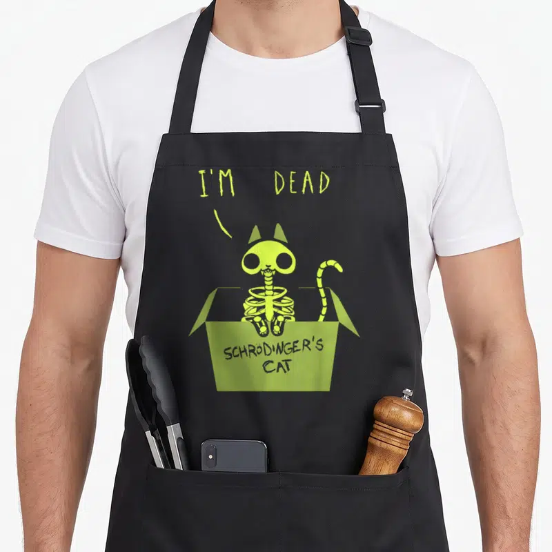Tablier de cuisine noir avec un chat squelette vert dans une boîte et le texte I'm Dead en haut.