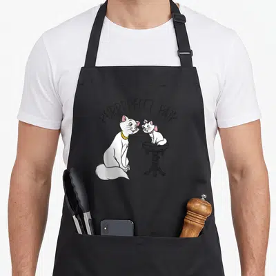 Tablier de cuisine noir avec Marie et ses chatons blancs sur une petite table