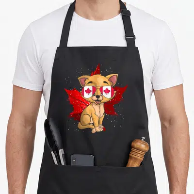 Tablier de cuisine noir avec un chat muni de lunettes affichant une feuille d'érable canadienne sur fond de grande feuille rouge.