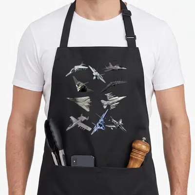 Tablier de cuisine noir avec neuf illustrations d'avions de combat F22 Raptor F18 Hornet F35 F15 F16 F117 A10 F4 Tomcat disposés en grille.