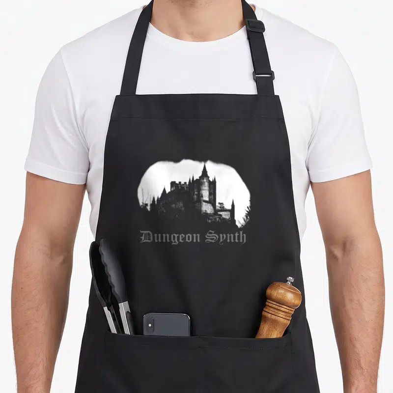 Tablier de cuisine noir avec silhouette de château et inscription Dungeon Synth en typographie gothique blanche.
